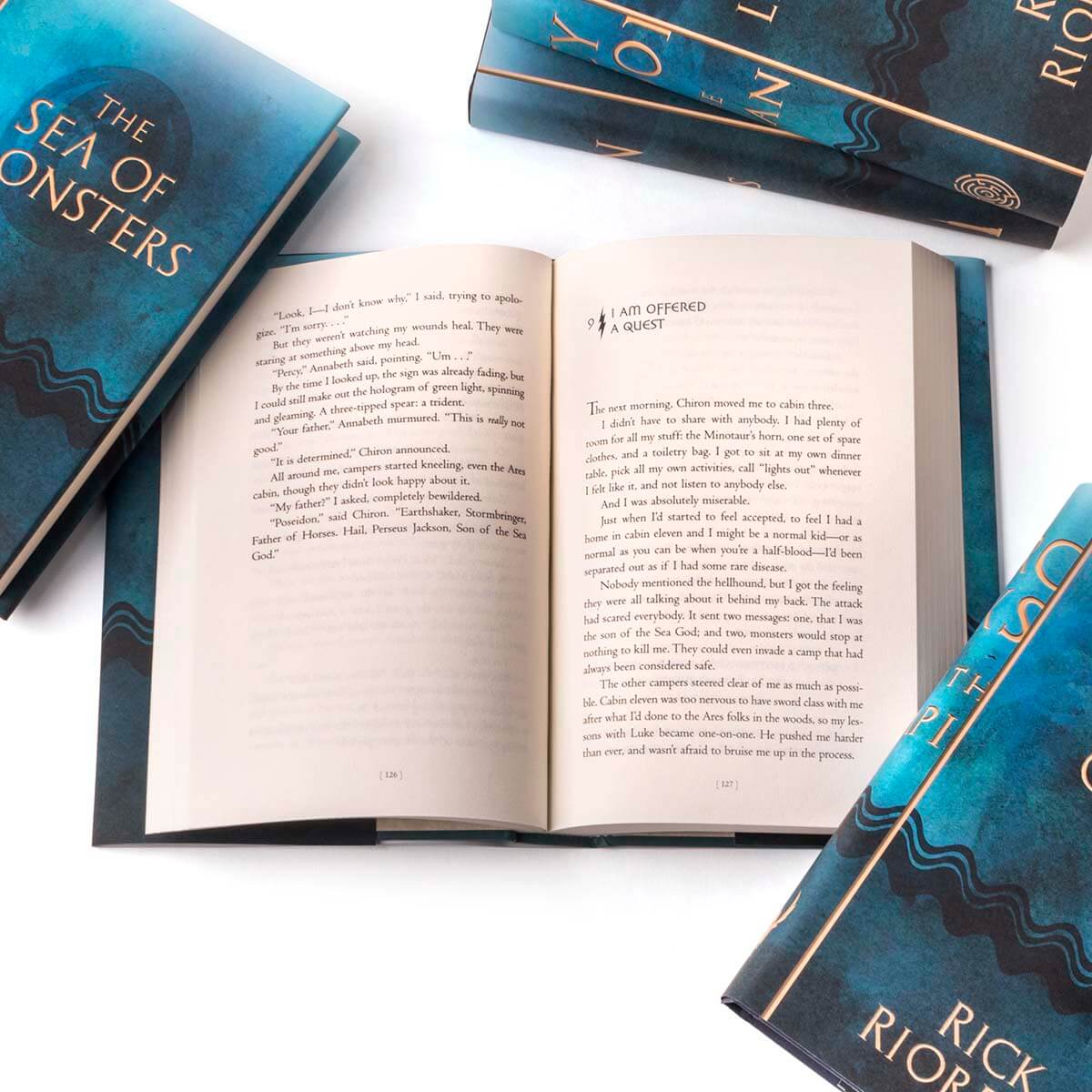 Close up oof open books in set to display print size. Open books surrounded by other books in the series displaying blue book covers.