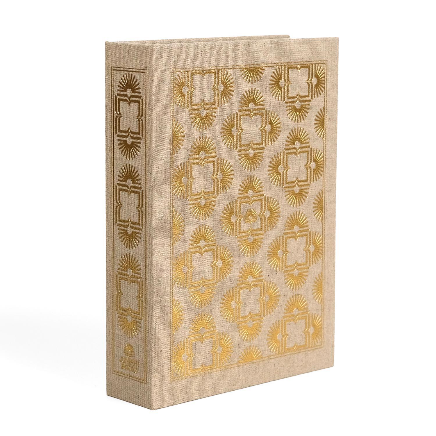 The beige dust jacket box by Juniper Books, resembling a hardcover book spines. The box features intricate, symmetrical patterns in metallic colors on the spine and covers—gold on a biege box. The Juniper Books logo is displayed at the bottom of each spine.