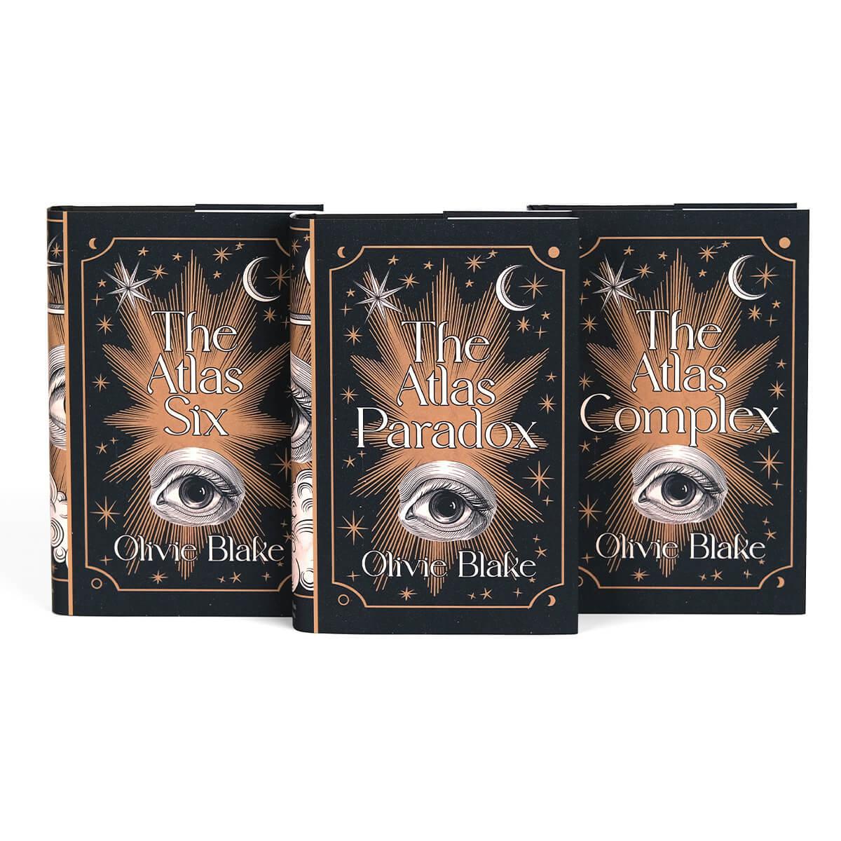 All Atlas Series book covers lined up. Front covers of jackets feature woodcut eye illustration between book title and author name surrounded by copper colored stars and ornamental detailing.