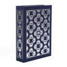 The navy dust jacket box by Juniper Books, resembling a hardcover book spines. The box features intricate, symmetrical patterns in metallic colors on the spine and covers—silver on a navy blue box. The Juniper Books logo is displayed at the bottom of each spine.