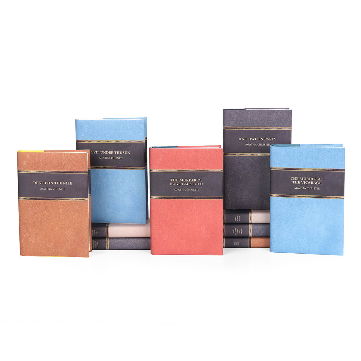 Agatha Christie books wrapped in custom collectible faux leather dust jackets  in black, beige, blue, red, light brown from Juniper Custom. Dust jacket covers feature book title and author name in gold color san serif set against black.