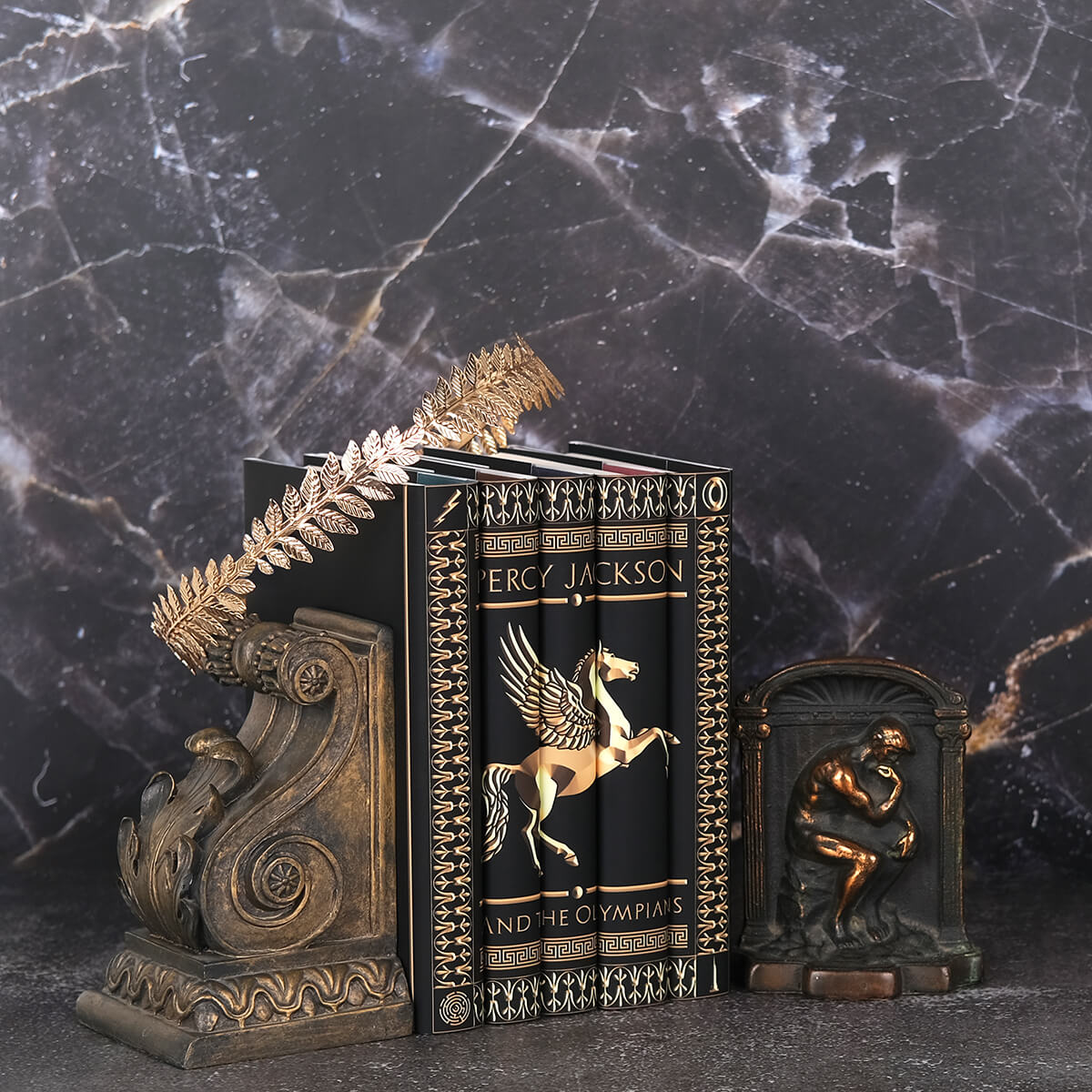Custom collectible Percy Jackson Legendary Book Set from Juniper Custom sitting against black marble with a gold crown and bronze book ends.