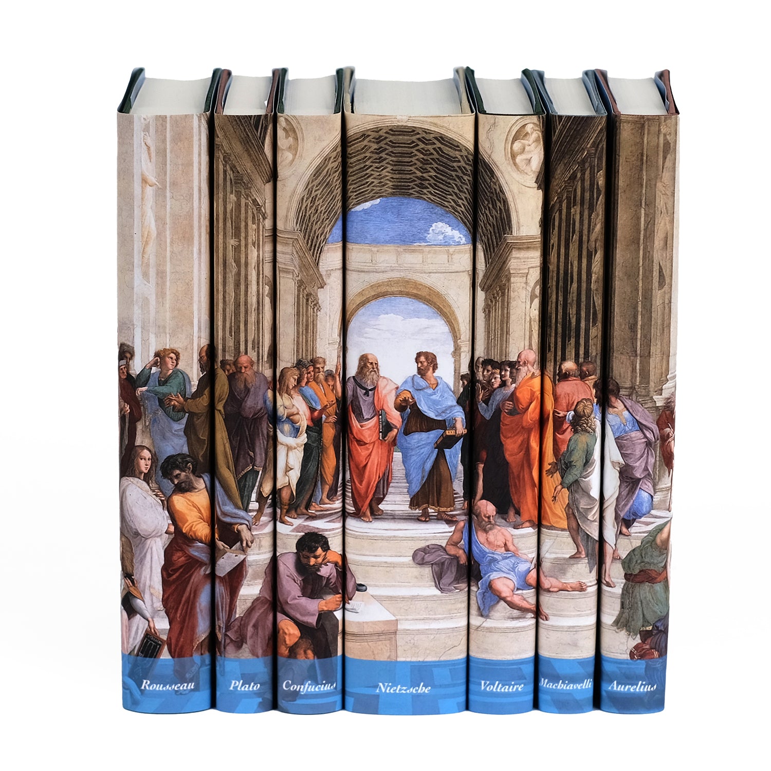 A set of seven hardcover books placed side by side, with custom dust jackets that create a continuous image of Raphael's famous painting The School of Athens. The spines of the books depict various philosophers and scholars engaging in conversation. Each book is labeled at the bottom with the names of influential thinkers: Rousseau, Plato, Confucius, Nietzsche, Voltaire, Machiavelli, and Aurelius. The background shows classical architecture with a vaulted ceiling and arches.