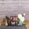 The Hunger Games Book Set by Juniper Books sitting against wood background surrounded by white roses, glass jars, and jute textile.