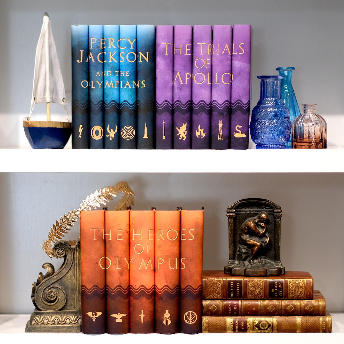Trials of Apollo, Percy Jackson and the Olympians, and The Heroes of Olympus custom collectible book sets from Juniper Books on a white book shelf.